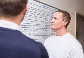 Man looks at a board with tasks at a office