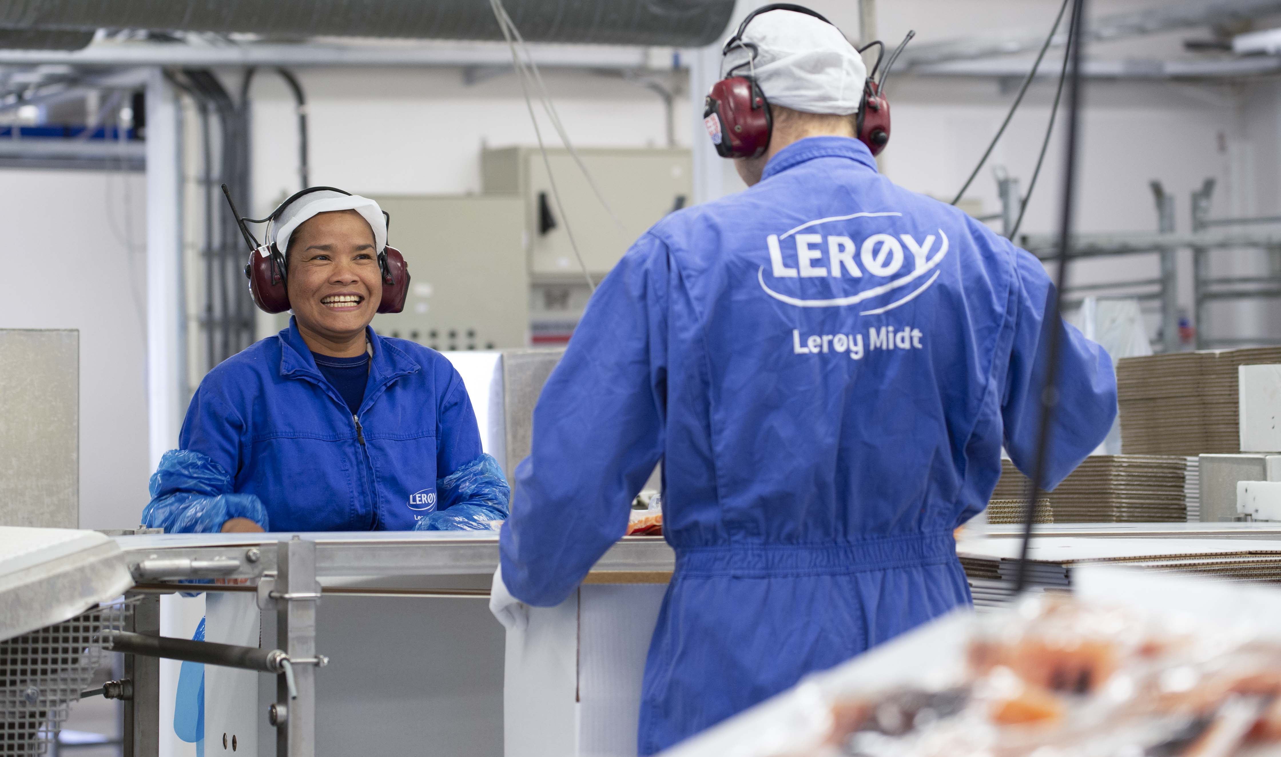 Two employees working at the facory in blue workwear