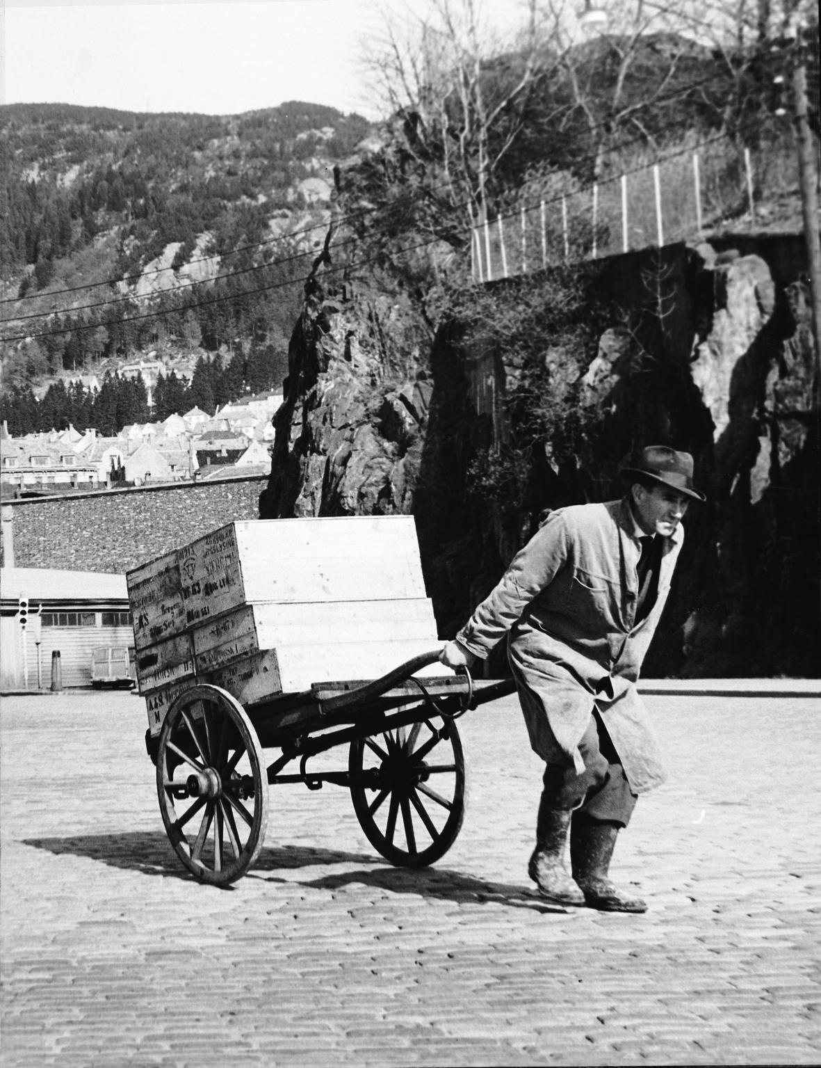 Black and white photo of a man moving fish boxes