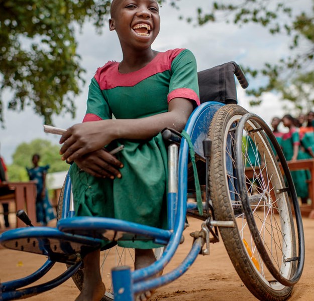 A child smiling in a wheelchair