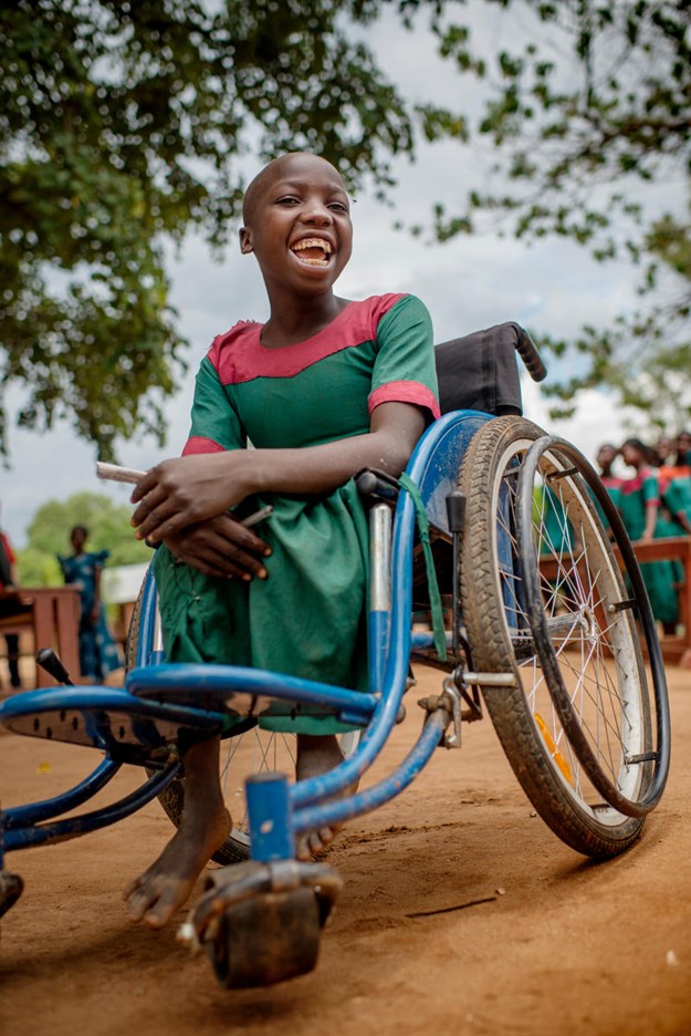 A child smiling in a wheelchair