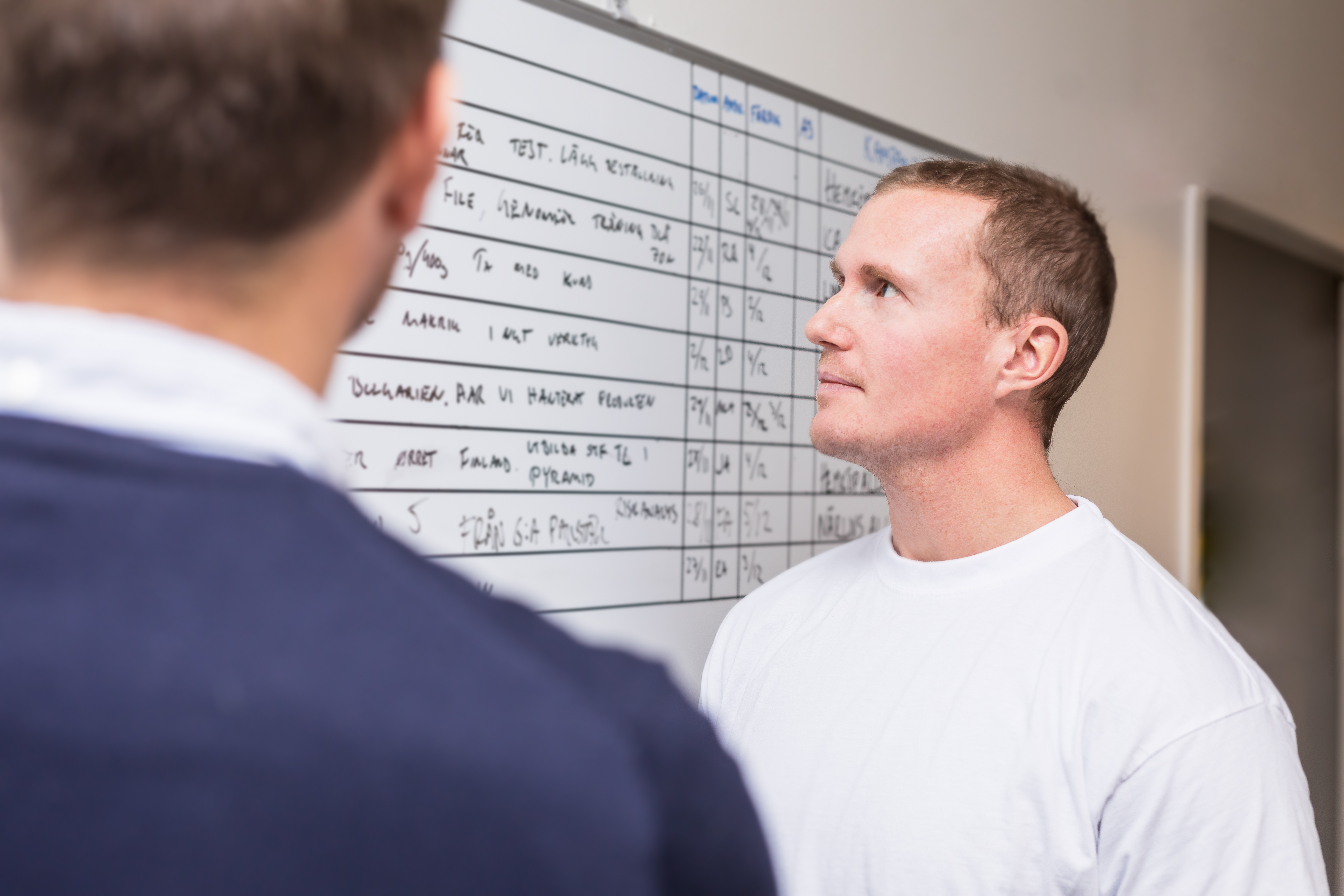 Man looks at a board with tasks at a office