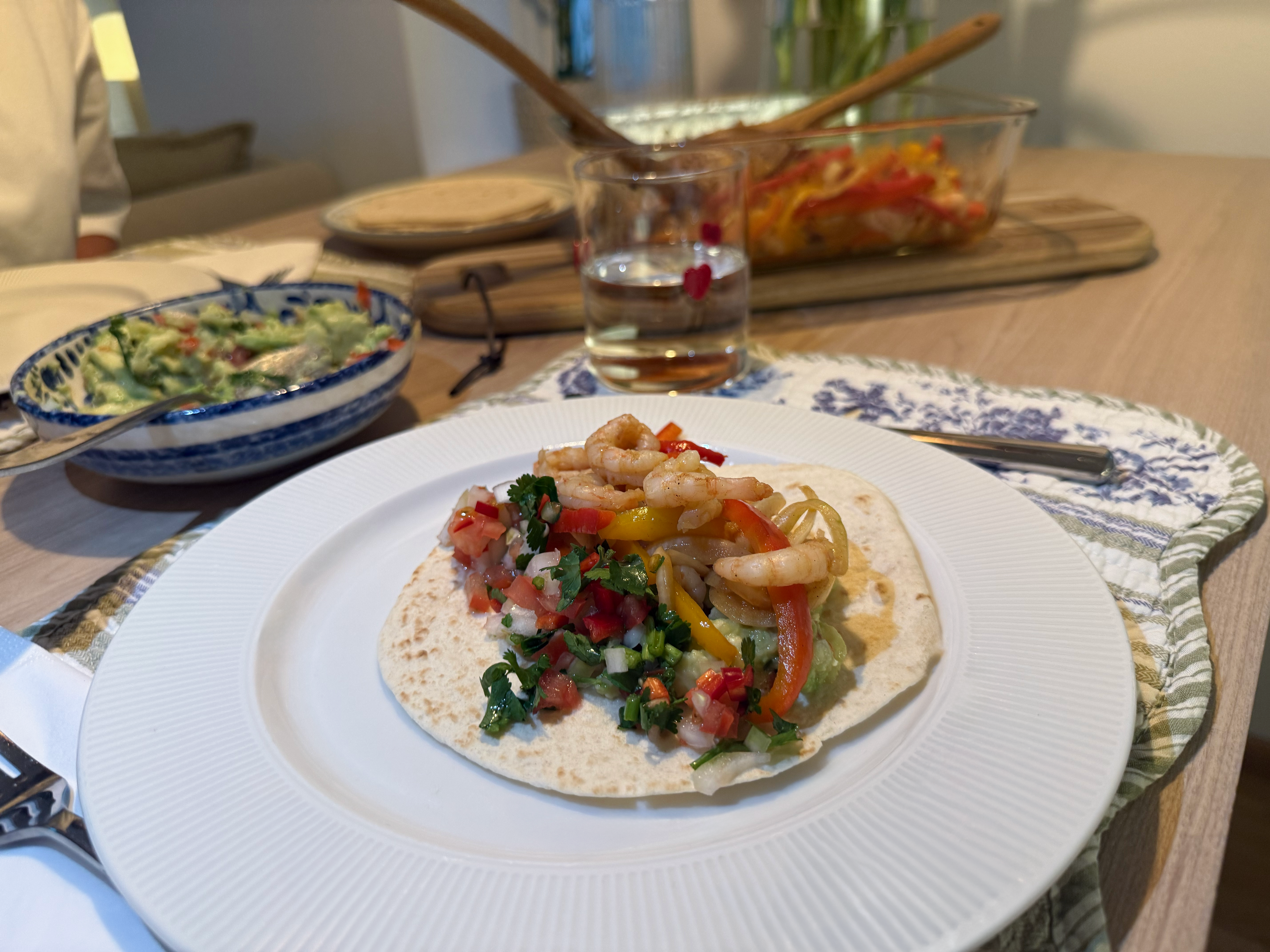 Pent dekket middagsbord, på fatet er rekefajitas på en lefse med salsa og guacamole. 