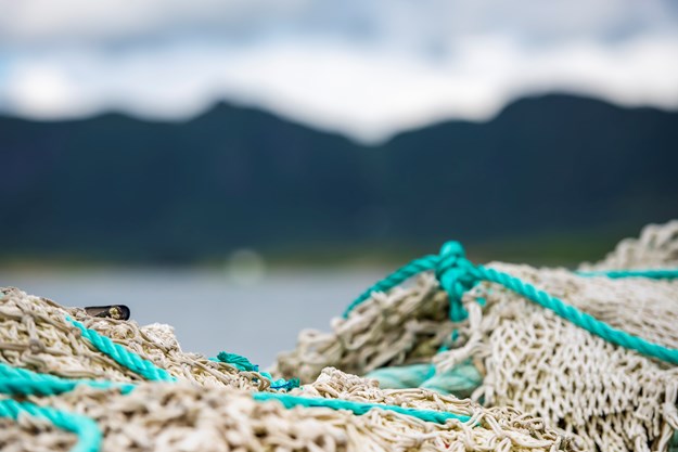 fishing line lying in the front in focus. In the back is skies, mountains and ocean blurry. 