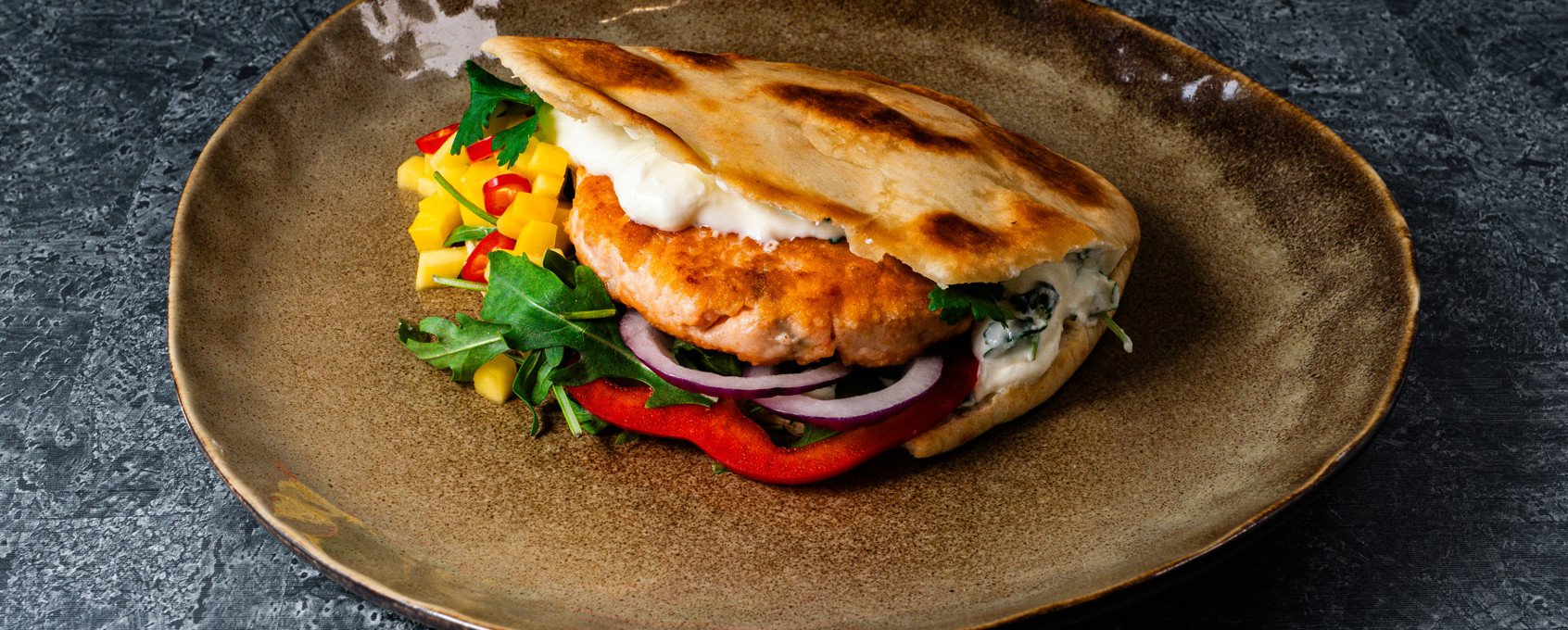 Fiskeburger i pitabrød med mango- og chilisalat
