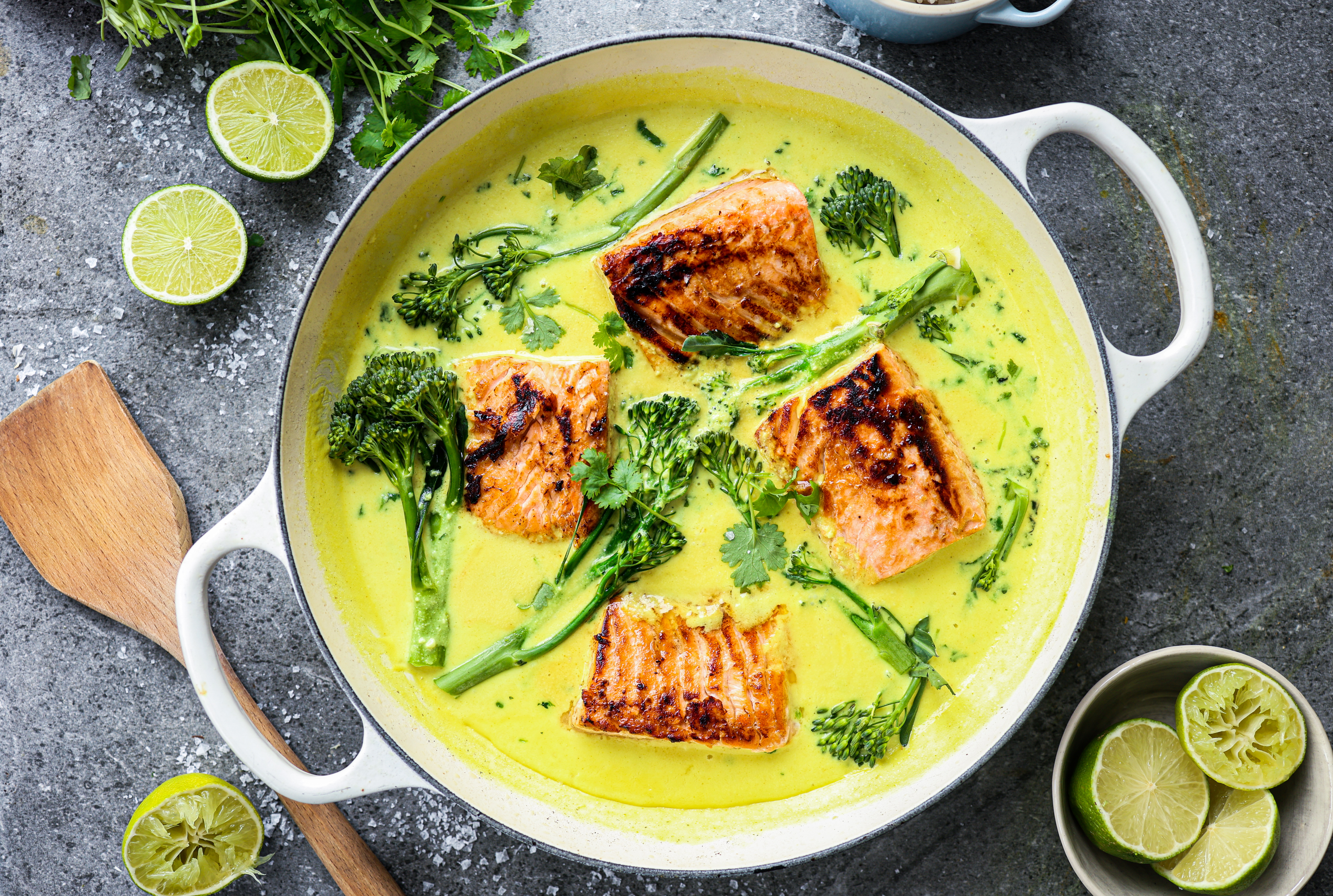 Fried salmon with salad and sesame seeds on a plate placed on a  nicely set table