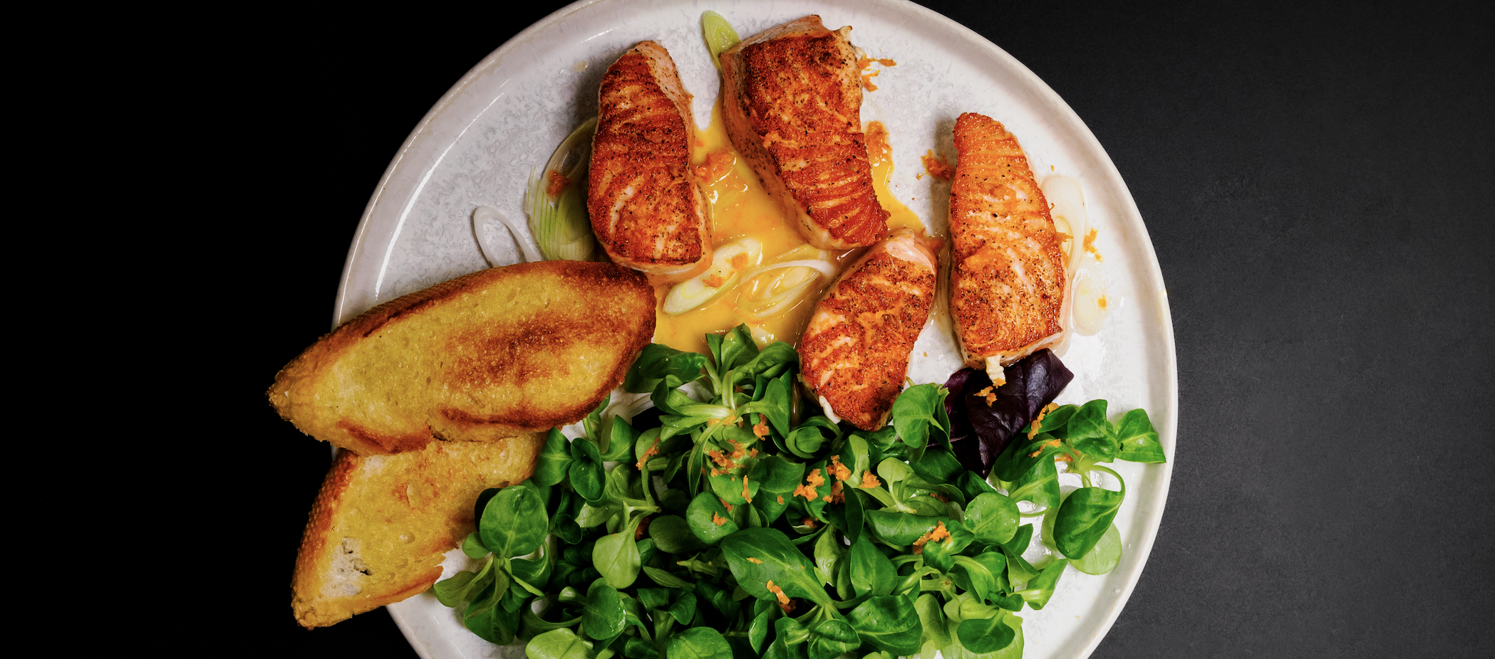 Laks med appelsinsaus, brød og salat