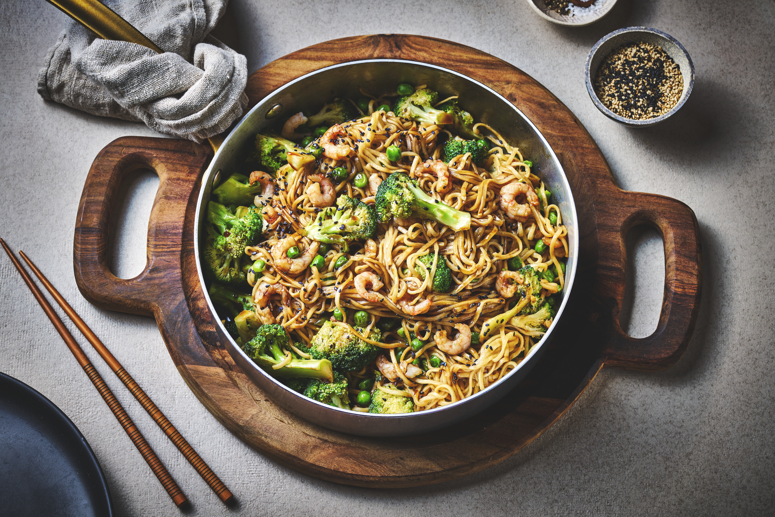 Wok med reker og brokkoli og erter servert i skål. 