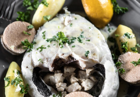 En tallerken på et bord med skreimølje og biter av sitron