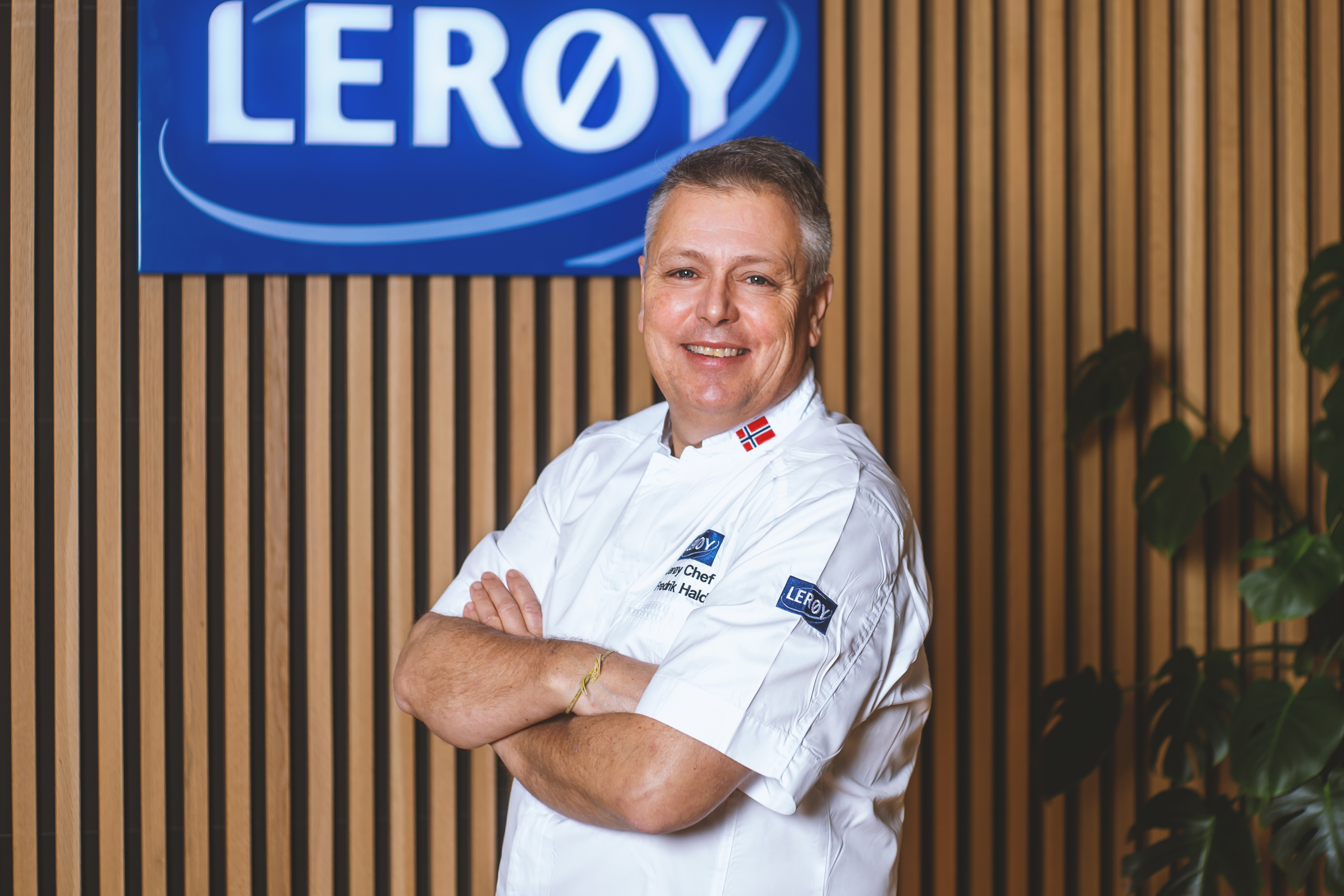 Smilende mann med armene i kryss.